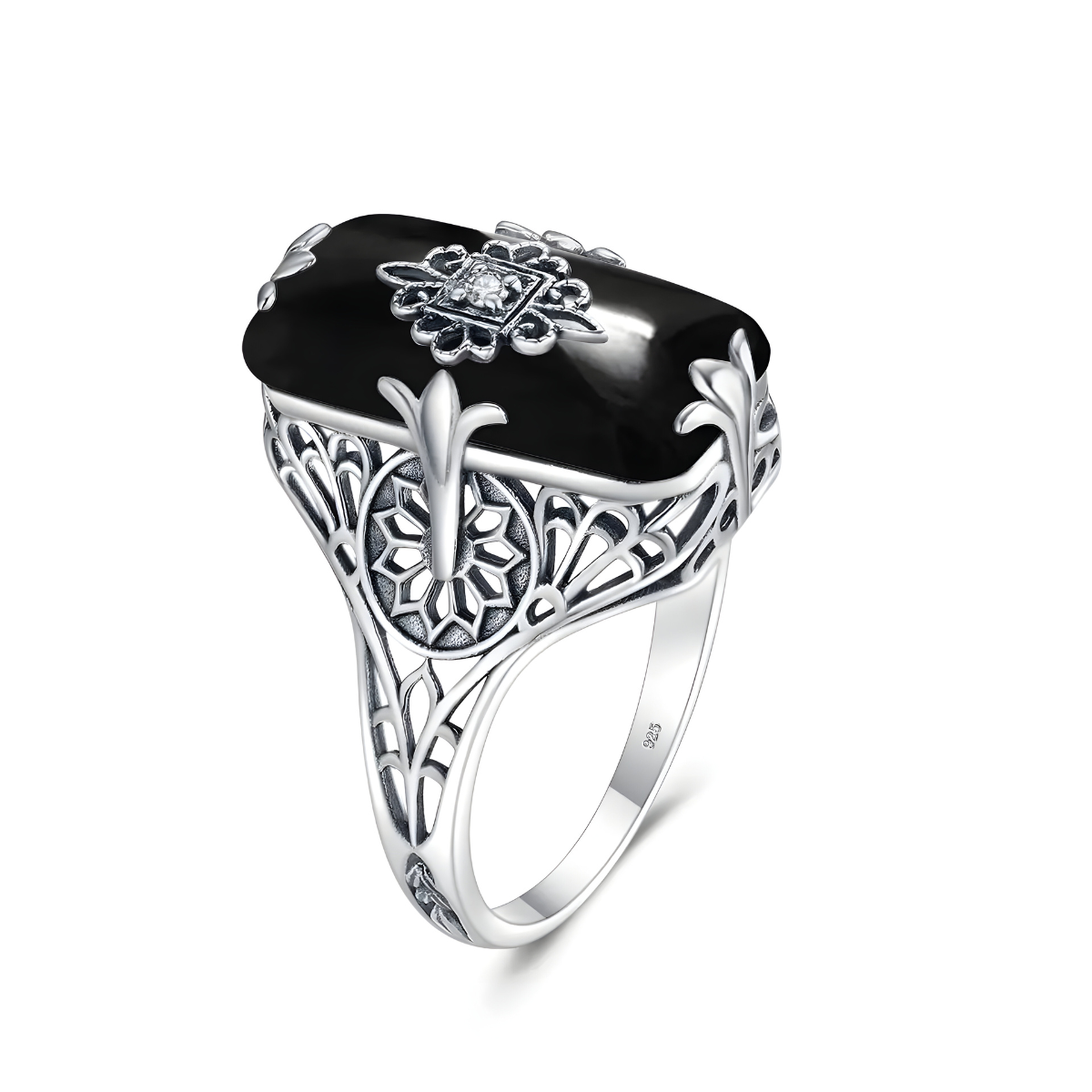 bague obsidienne rectangulaire bombée montée sur anneau argenté finement ciselé avec motifs floraux et ornement central en relief serti d’un petit oxyde blanc