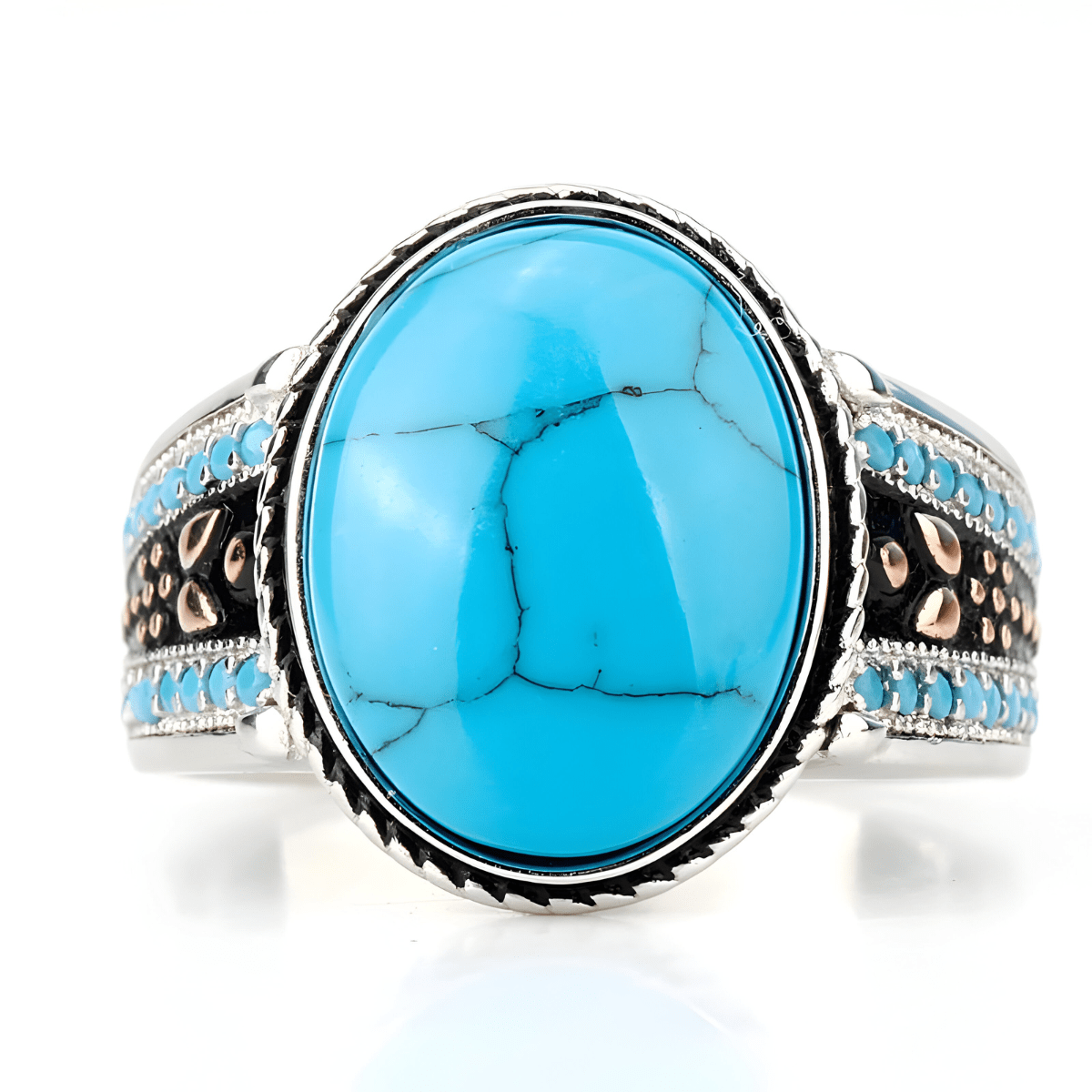 Bague turquoise cabochon avec grande pierre ovale bleue montée sur un anneau argenté orné de perles turquoise et de motifs noirs et cuivrés