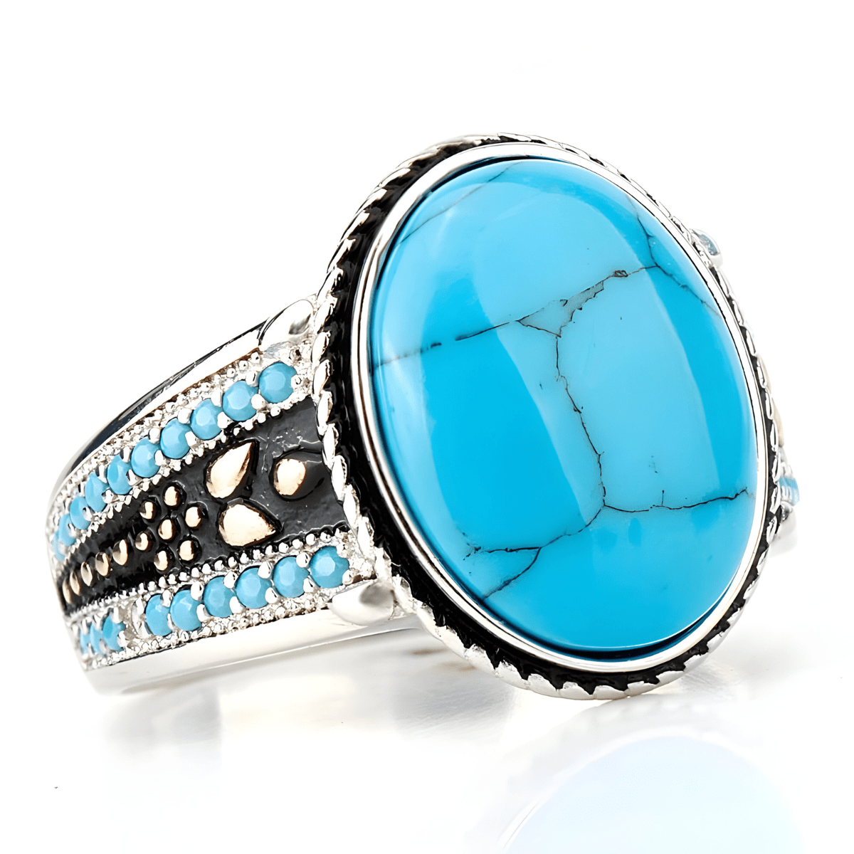 Bague turquoise cabochon avec pierre ovale bleu ciel sertie sur un anneau argenté décoré de perles turquoise et de motifs noirs et cuivrés