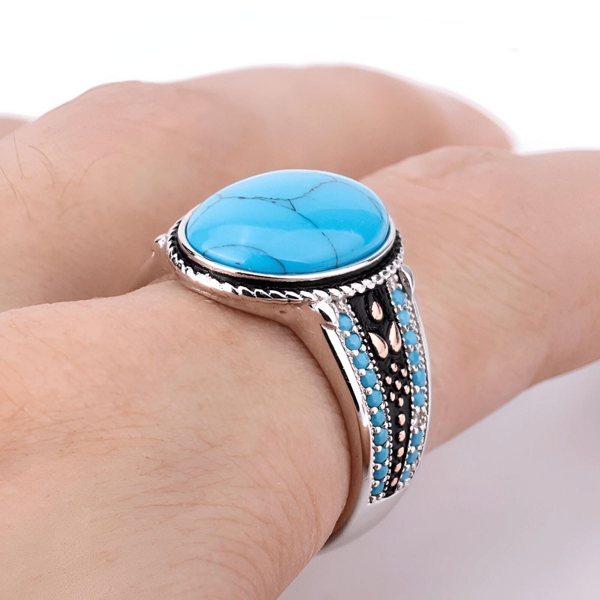 Bague turquoise cabochon en argent avec pierre ovale bombée et incrustations bleues sur anneau sculpté