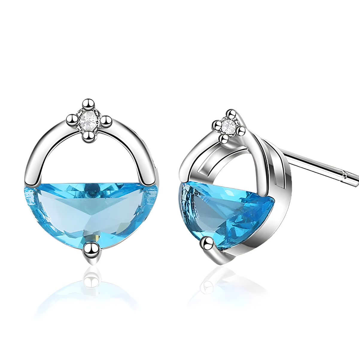 Boucles d’oreilles aigue marine avec pierre bleue facettée en demi-lune sertie dans une monture argentée ornée d’un petit cristal