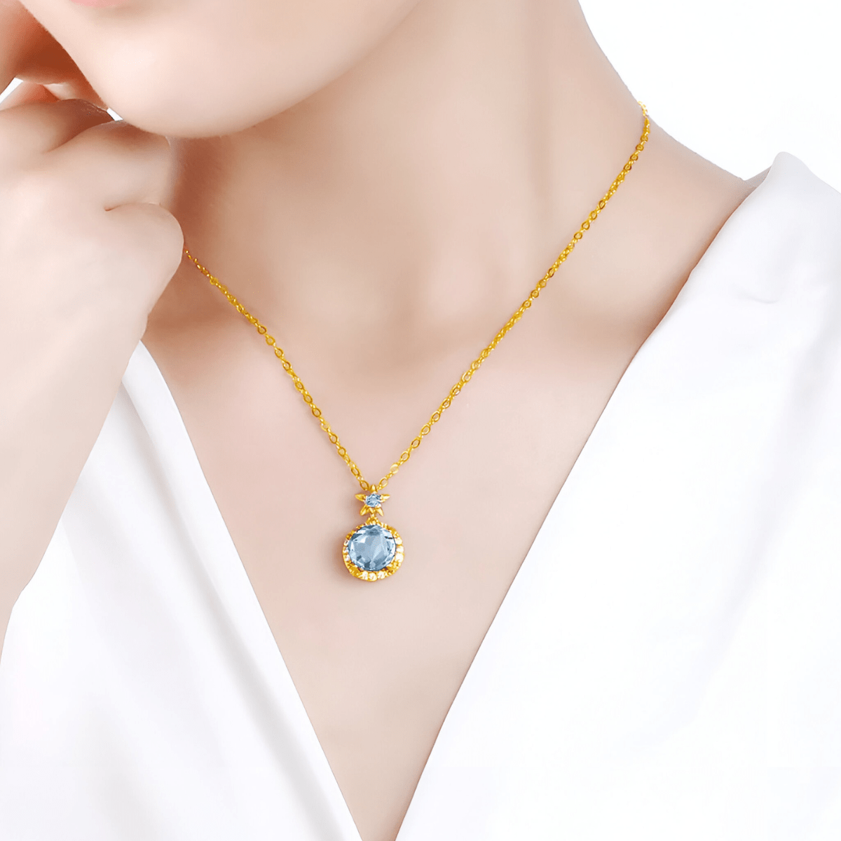 Collier aigue marine avec pendentif rond doré orné de cristaux et étoile sertie sur chaîne dorée