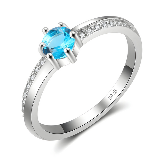 bague aigue marine argent avec pierre ronde facettée bleu clair sertie sur anneau pavé de zirconium