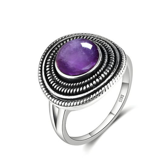 bague améthyste vintage avec pierre ovale violette en cabochon montée sur large monture ovale décorée de motifs perlés