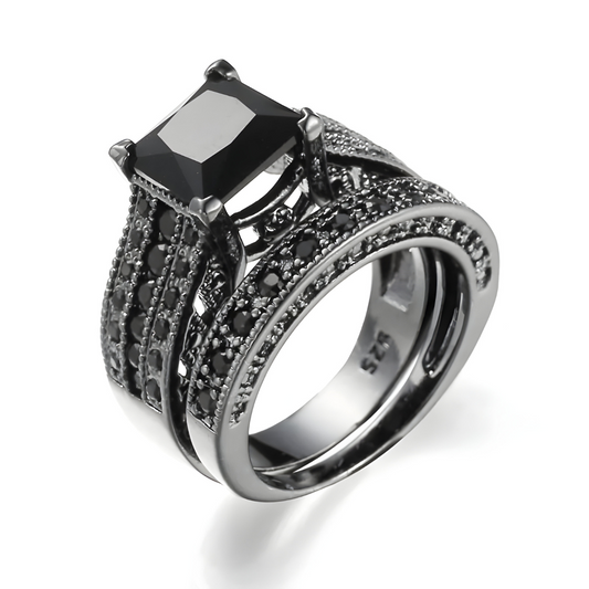 bague obsidienne avec pierre noire rectangulaire facettée sertie de griffes sur monture noire pavée de multiples pierres rondes
