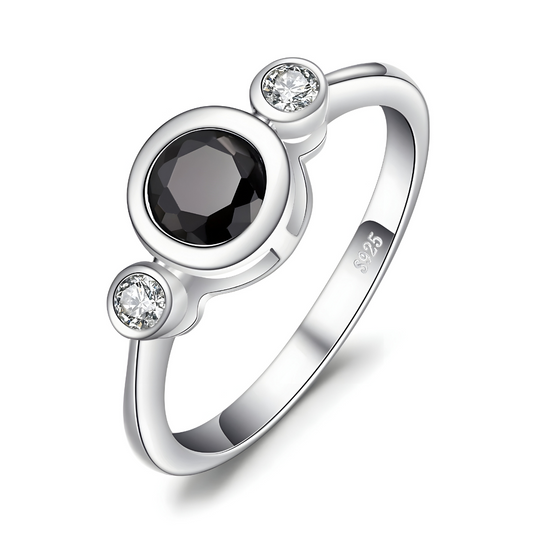 bague obsidienne avec pierre noire ronde facettée au centre encadrée de deux pierres blanches rondes sur monture argentée lisse