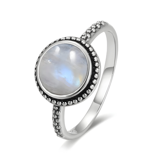 Bague pierre de lune fine avec gemme ronde à reflets bleutés sertie sur anneau en argent décoré de petits motifs perlés