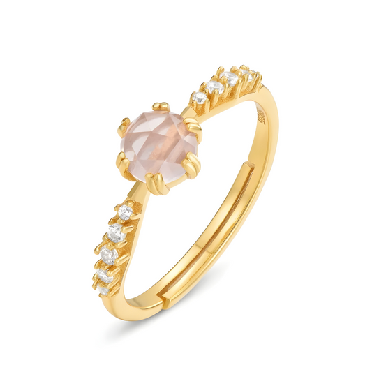 Une bague Quartz Rose Or en or jaune, ornée d’une pierre rose facettée et de petits cristaux étincelants sur l’anneau