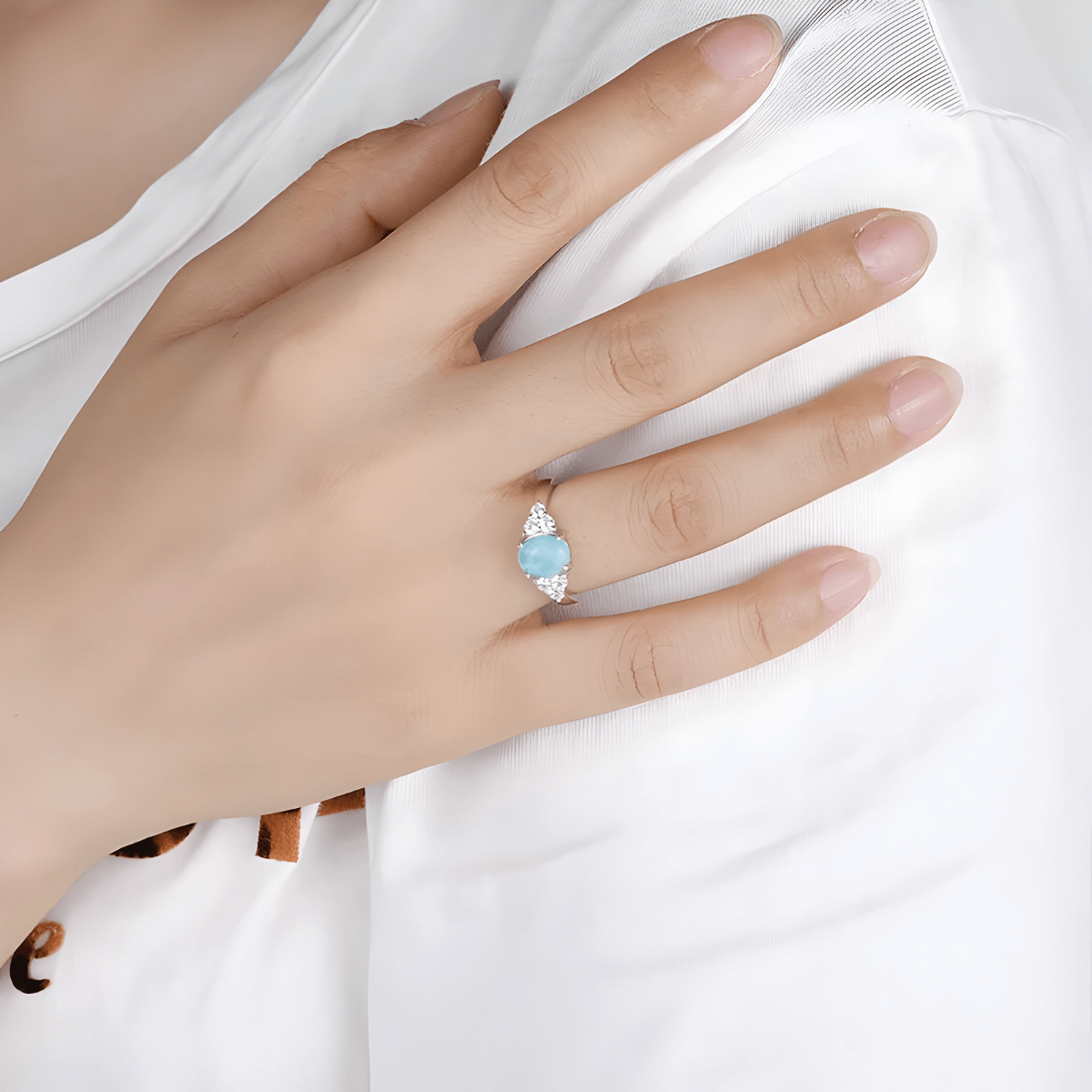 Bague aigue marine brute en argent portée à la main avec pierre bleue ovale et éclats blancs