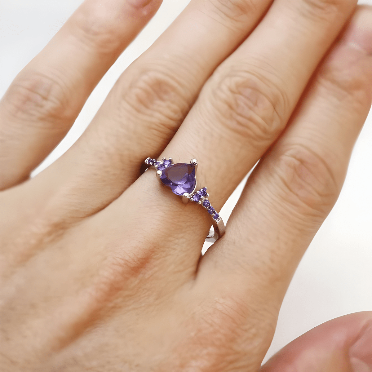 Bague améthyste argent avec pierre en forme de goutte et petits cristaux violets sur l’anneau