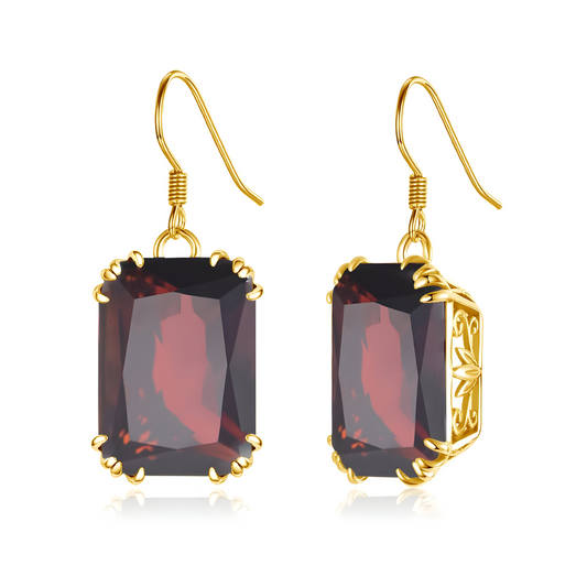 Boucles d’oreilles en grenat rouge taille émeraude, montées sur un crochet doré avec griffes finement ouvragées, alliant éclat intense et élégance vintage