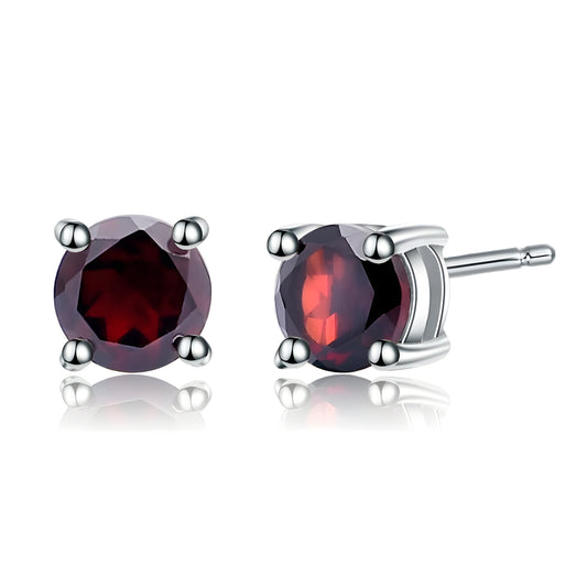 Boucles d’oreilles puces en grenat rouge profond, serties en griffe sur monture argentée, pour une touche discrète et sophistiquée