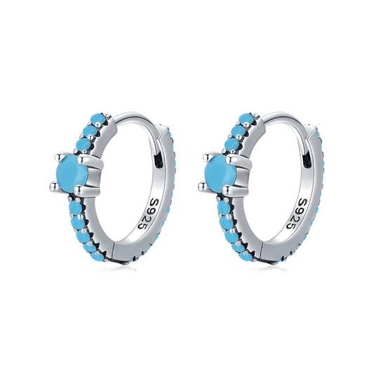 Boucles d’oreilles Turquoise créoles argent ornées de perles naturelles turquoise serties sur monture incurvée finition polie vue oblique