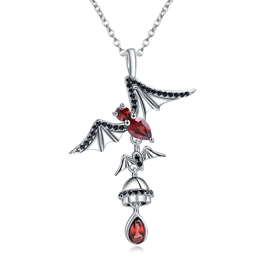 Un collier Grenat en argent, orné d’un pendentif représentant une créature ailée avec un corps en pierre rouge et une goutte grenat suspendue