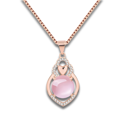 Un Collier Quartz Rose Or en or rose, orné d’une pierre rose sphérique et d’un motif ajouré en forme de cœur serti de petits cristaux